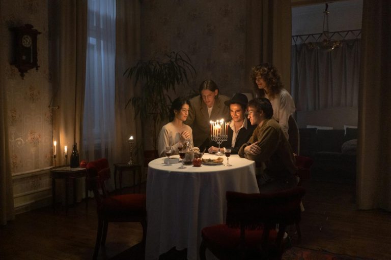 A family gathers around a menorah for a festive Hanukkah dinner, celebrating together indoors.