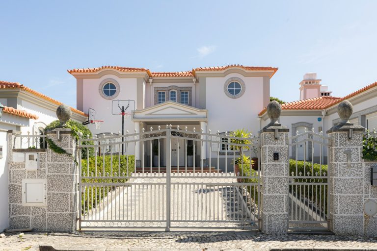 A luxurious mansion with a large front gate.