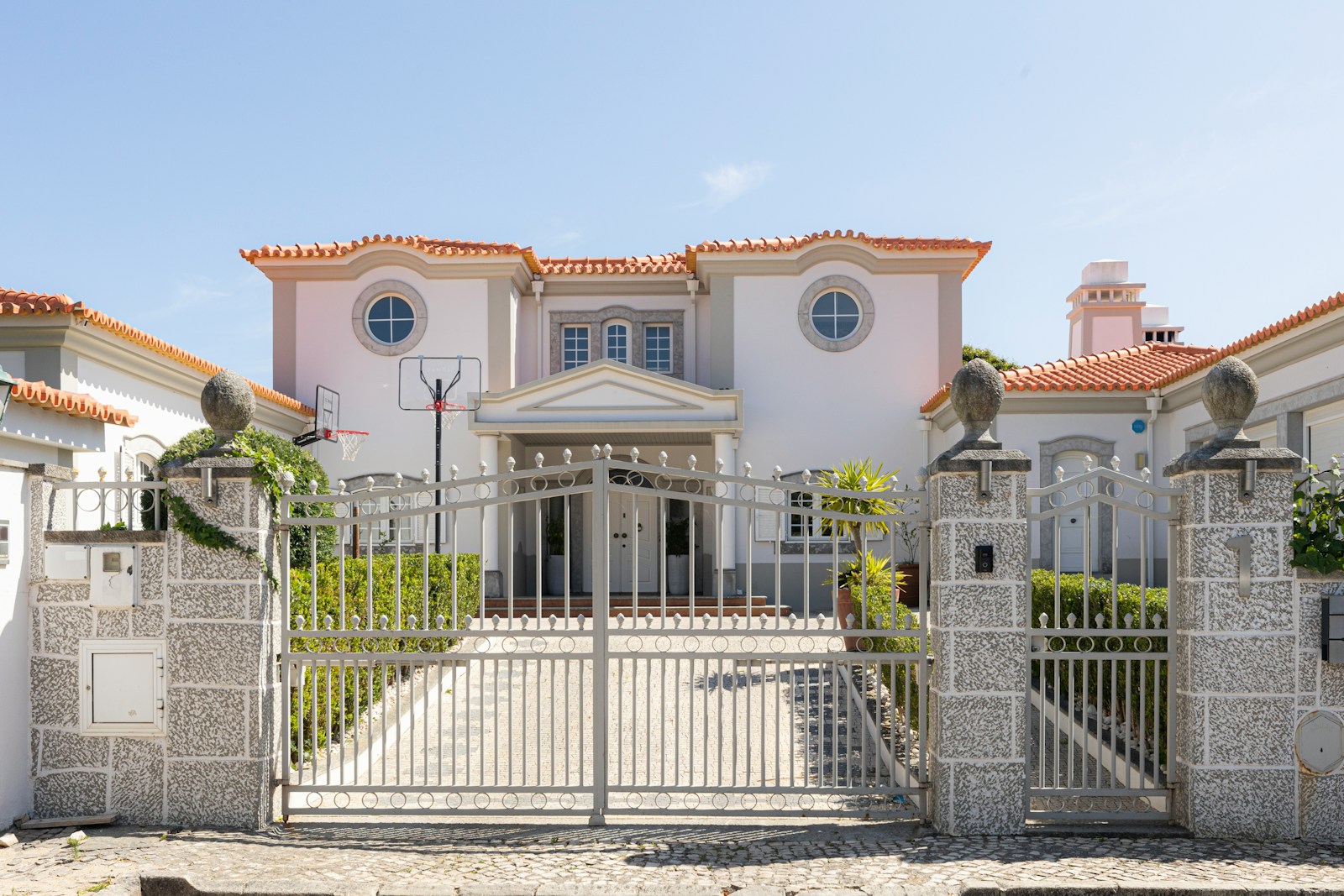 A luxurious mansion with a large front gate.