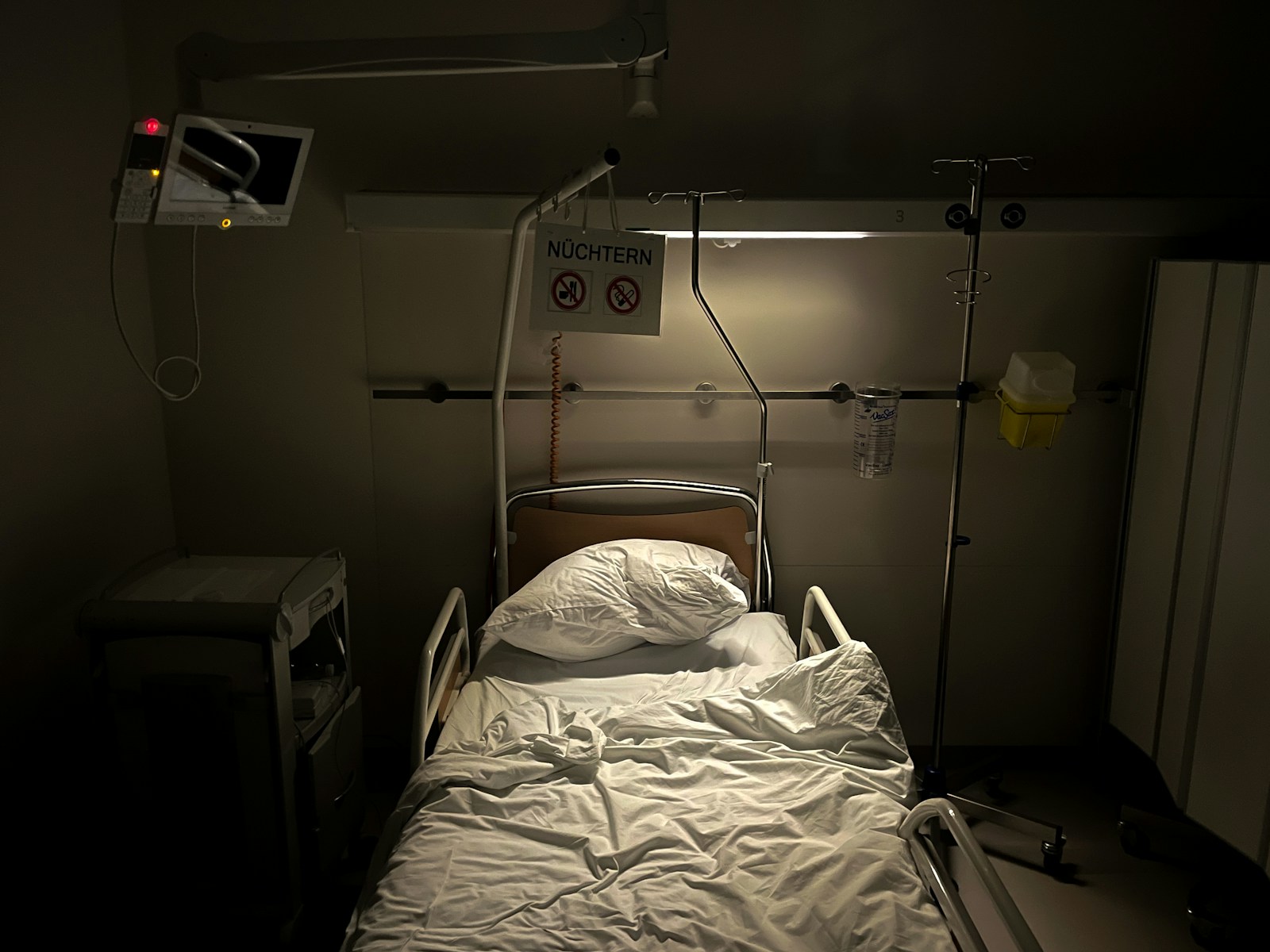 a hospital room with a bed and a monitor