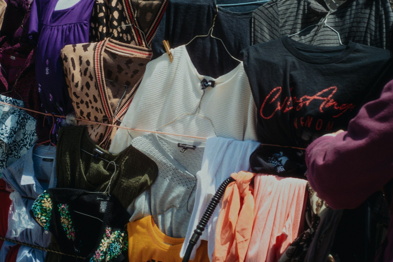 Clothes hang on a rack in a clothing store.