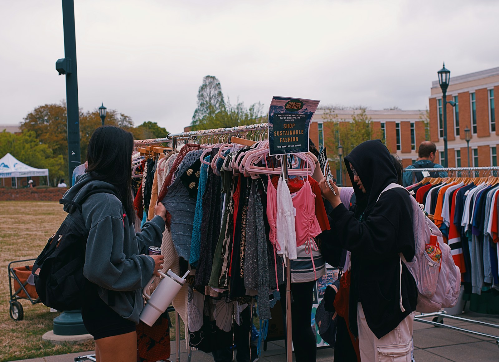 People browse clothes at an outdoor pop-up shop.