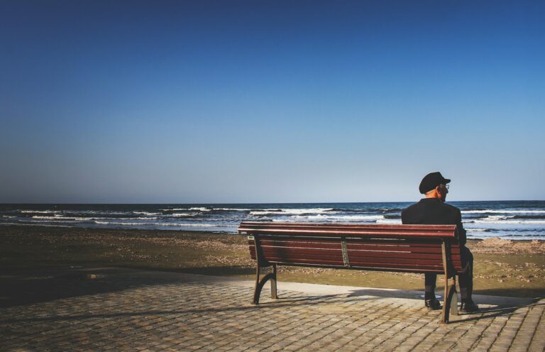 a person sitting on a bench at the beach