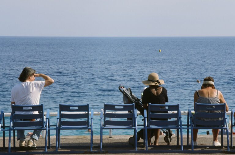 a group of people sitting on top of blue chairs