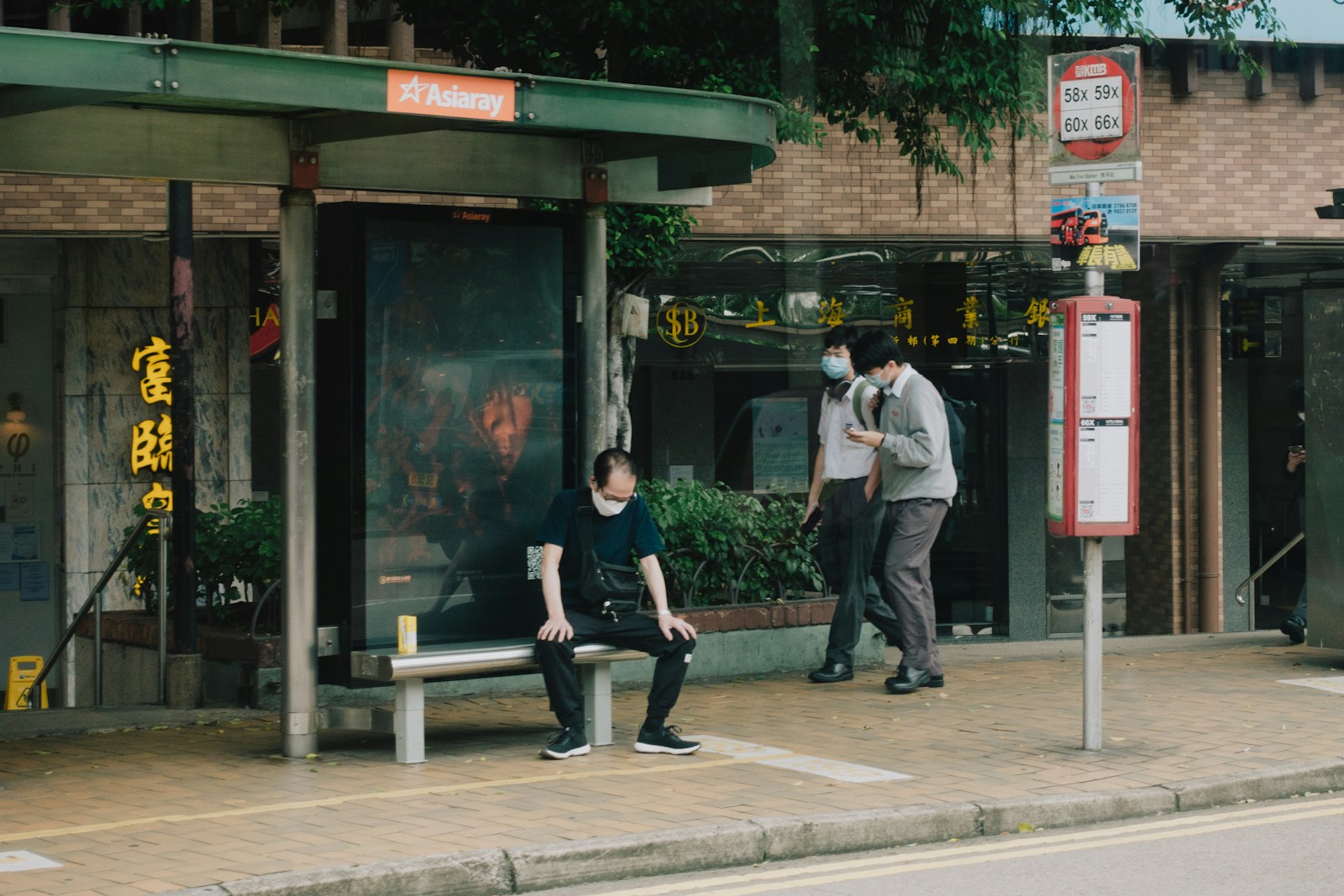 a man and a woman sitting on a bench in front of a building