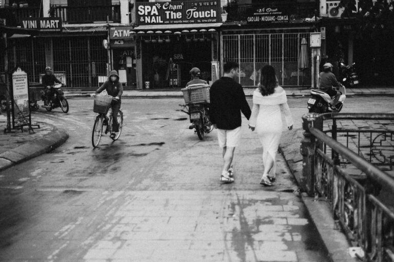 Couple holding hands walking on wet city street