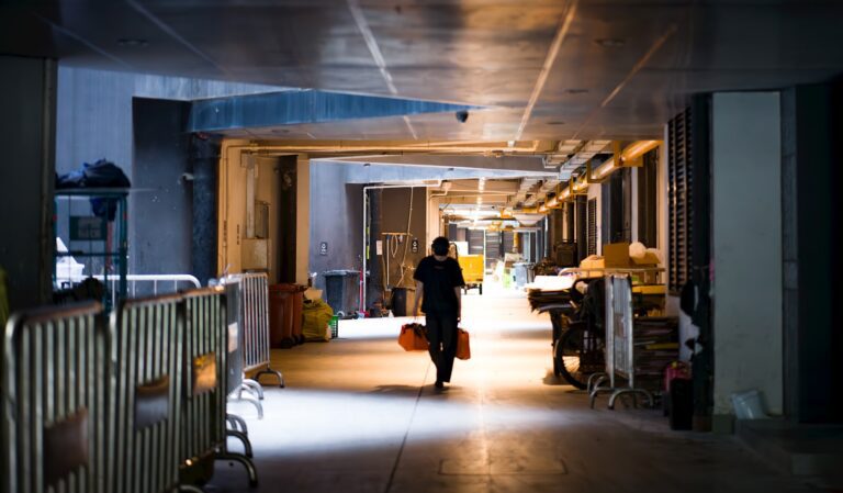 A person walking down a hallway with luggage
