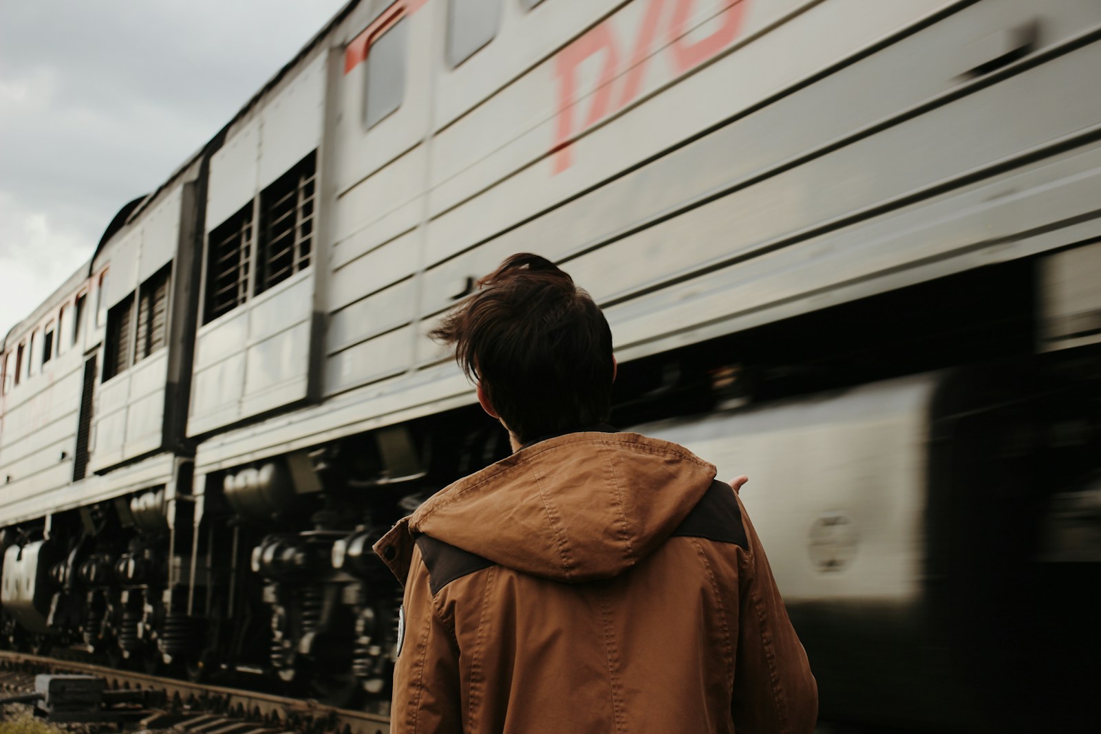 a person walking next to a train on the tracks