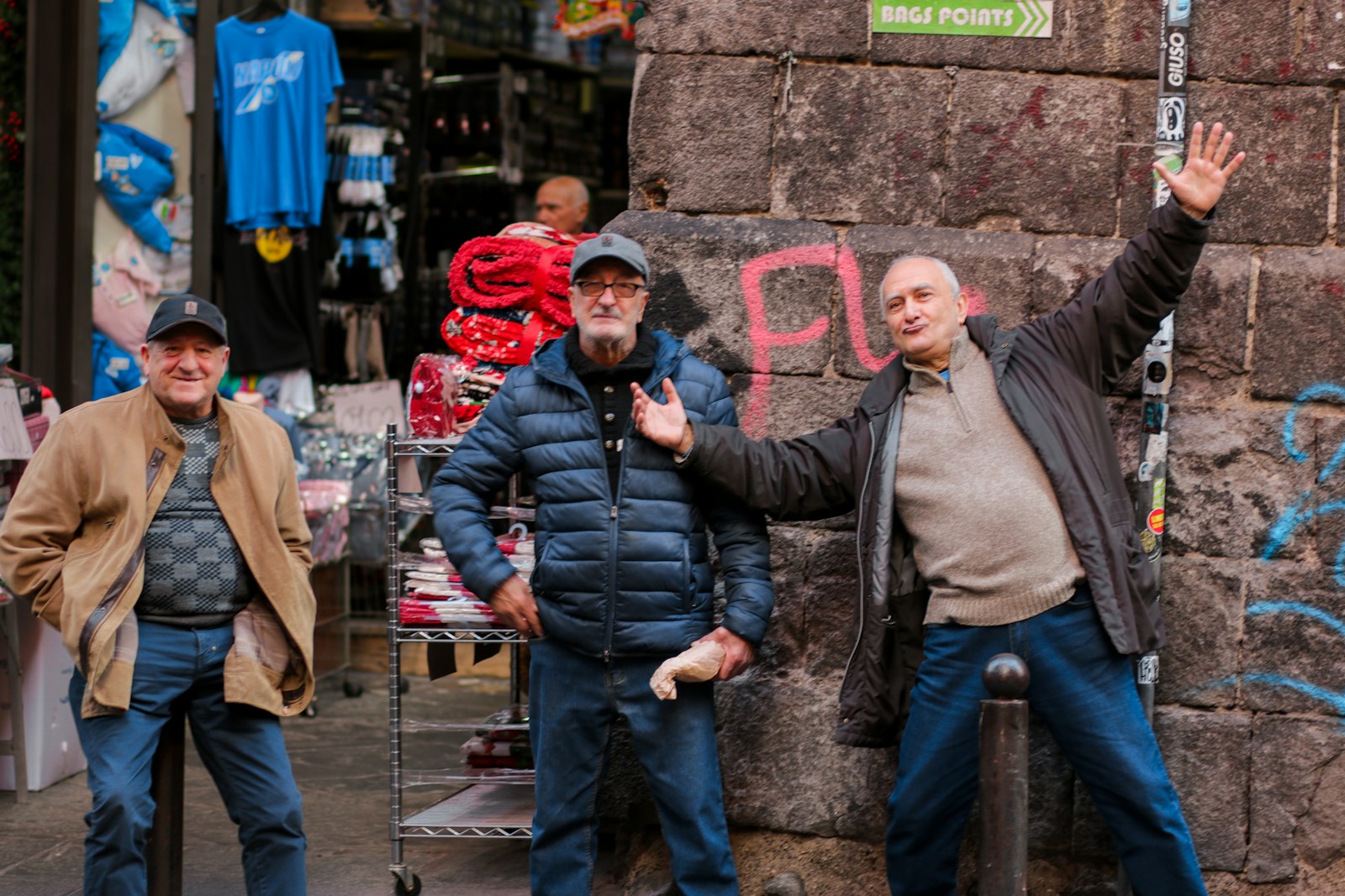 a group of men standing next to a stone wall