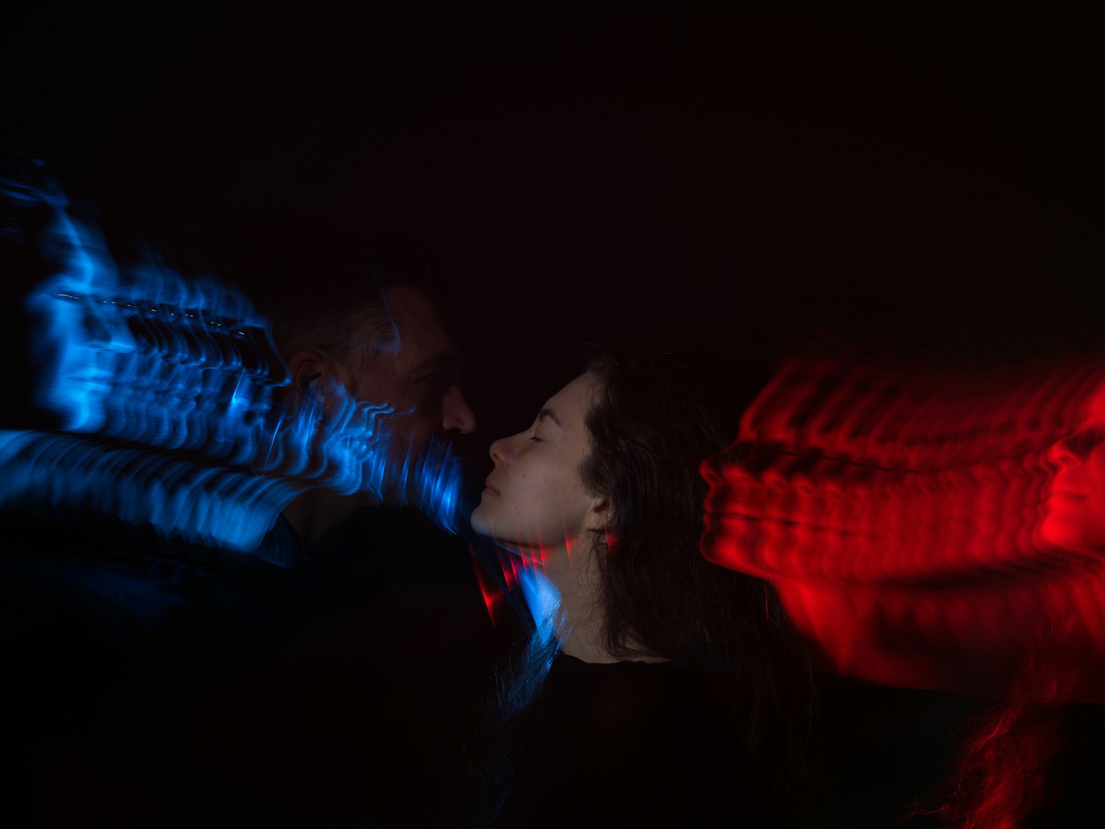 Woman's profile illuminated by red and blue lights.