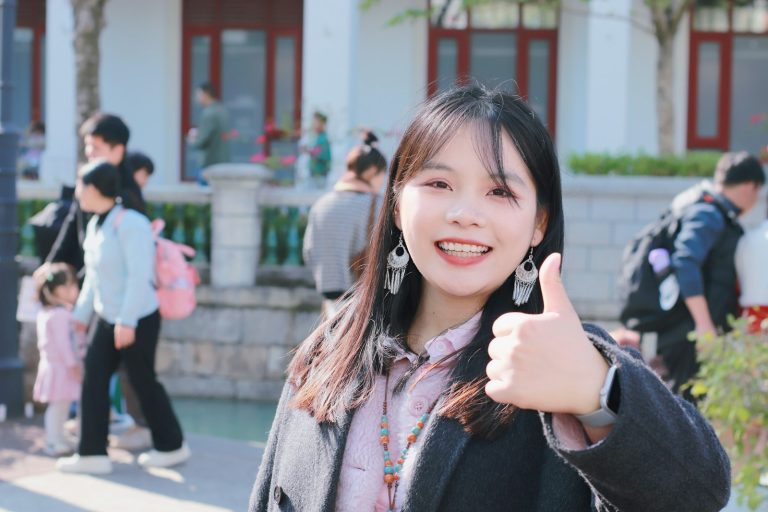 Young woman smiling and giving a thumbs up.