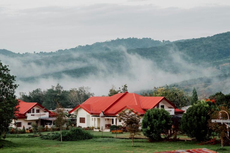 Charming rural houses with red roofs nestled in Valencia's misty mountainside landscape.