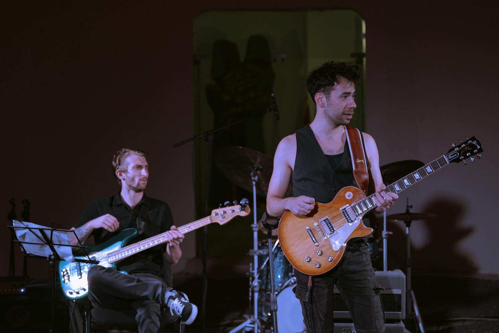 Dynamic live rock performance with musicians playing guitar and bass on stage.