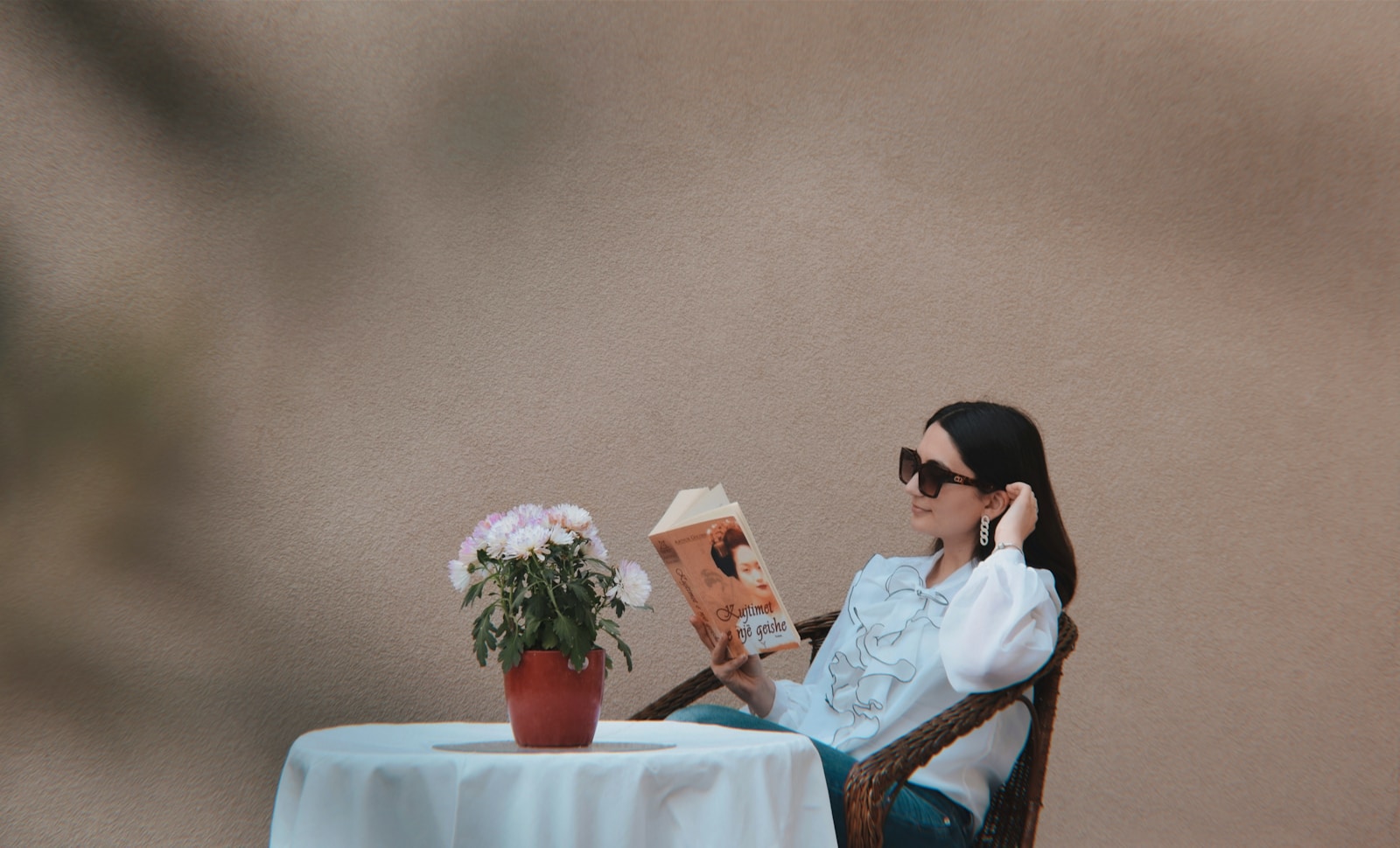 a person sitting at a table reading a book