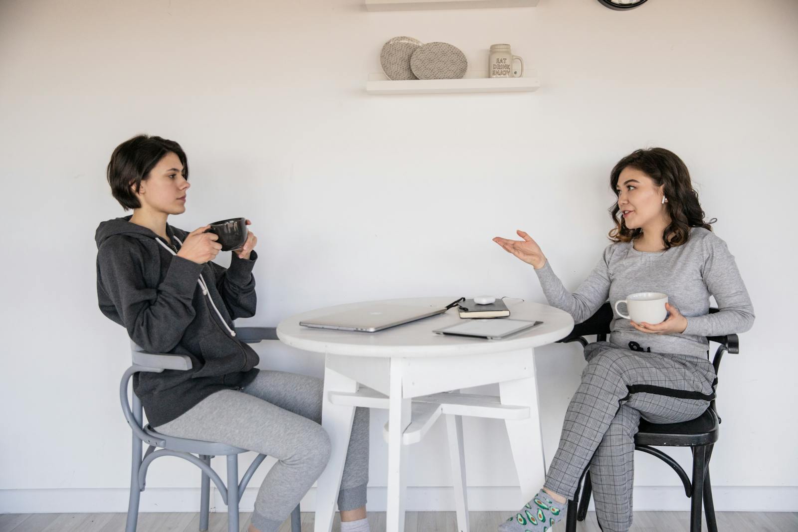 Two women enjoying a casual conversation with coffee in a cozy indoor setting, enhancing connections.