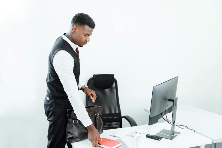Businessman arranging his desk at a modern, minimalist office workplace.