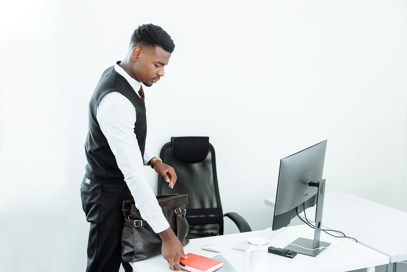 Businessman arranging his desk at a modern, minimalist office workplace.