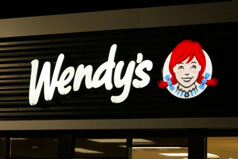 A wendy's sign is lit up at night