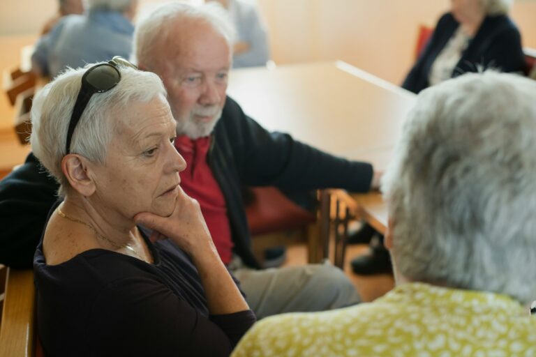 Elderly people are sitting and talking with each other.