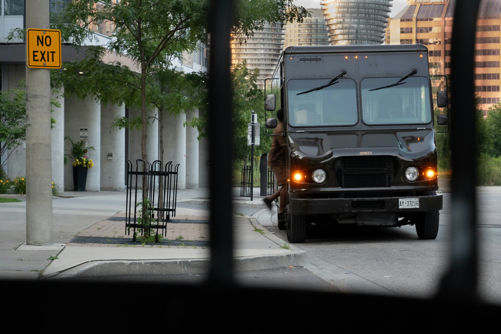 A black truck driving down a street next to tall buildings