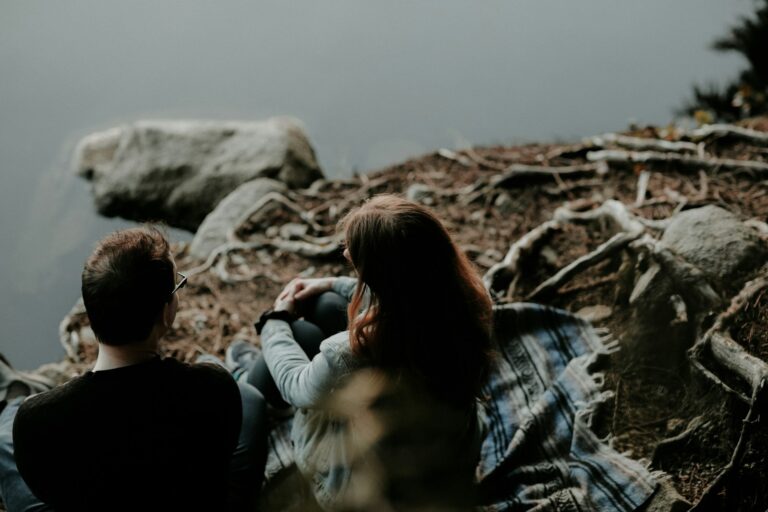 couple sitting near the body of water