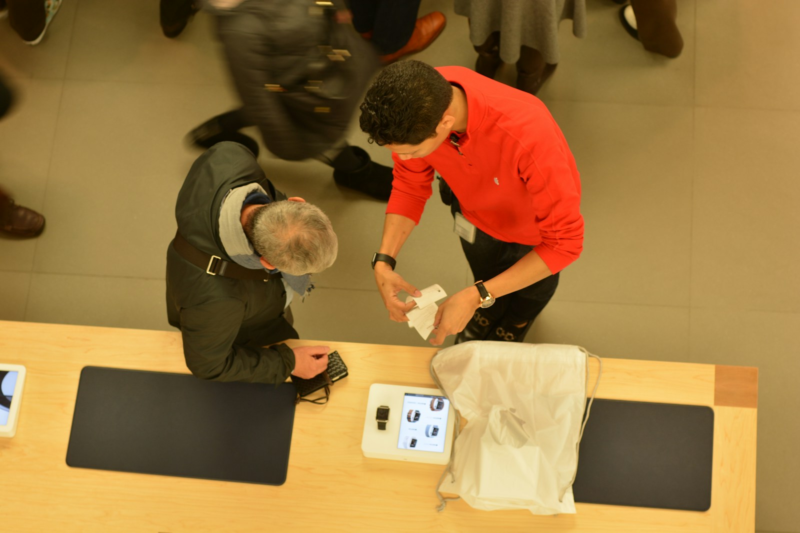 A store employee helps a customer at a counter.