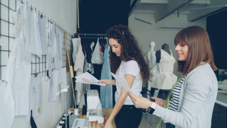 Two fashion designers collaborate in a workshop.