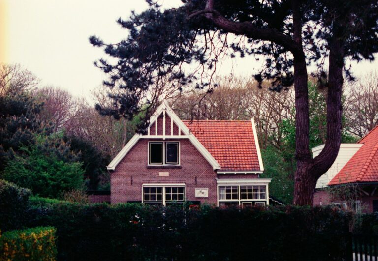 A brick house sits among the trees.