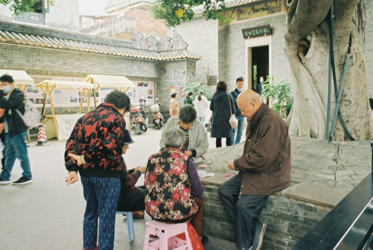 a group of people sitting on a bench in a courtyard