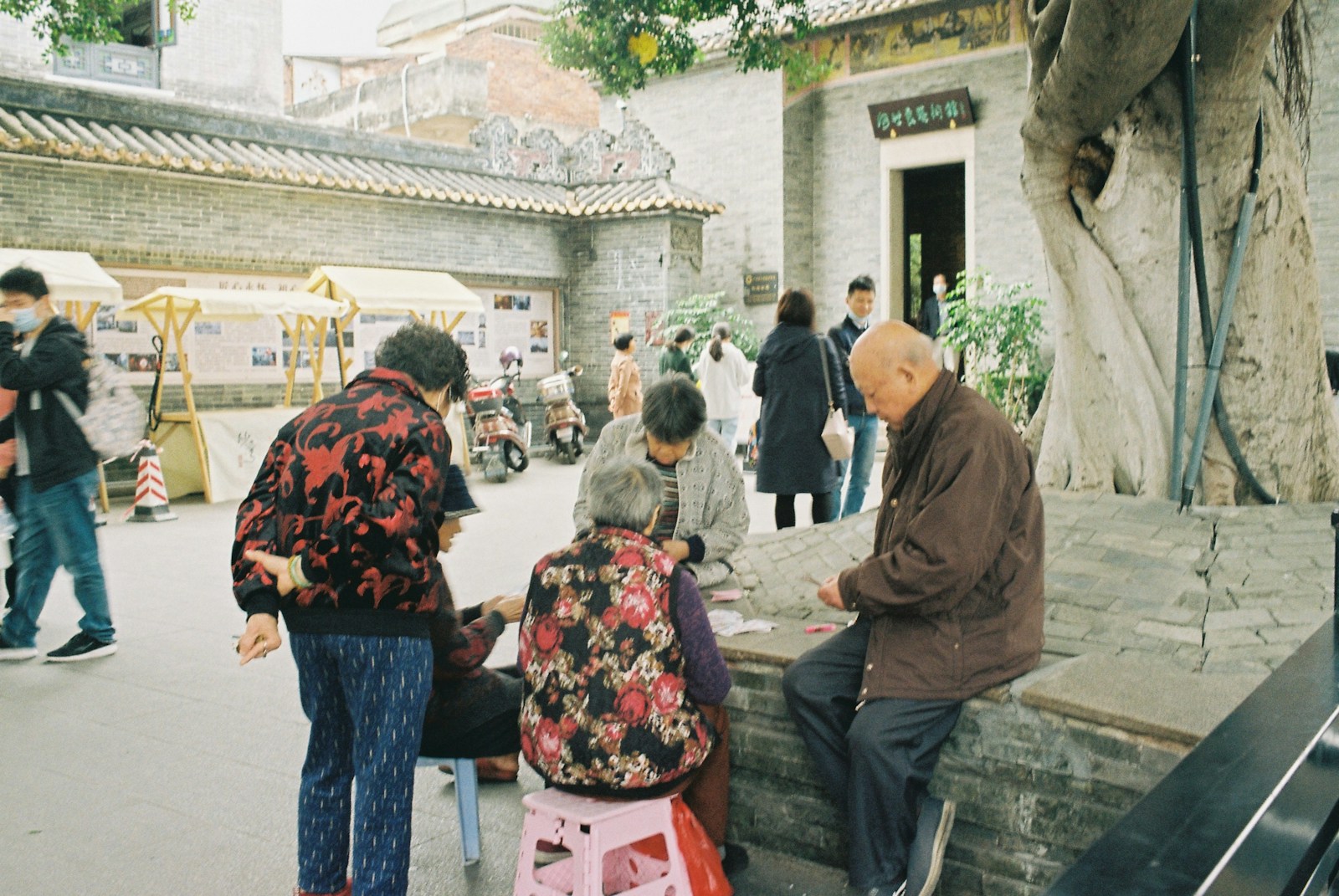 a group of people sitting on a bench in a courtyard