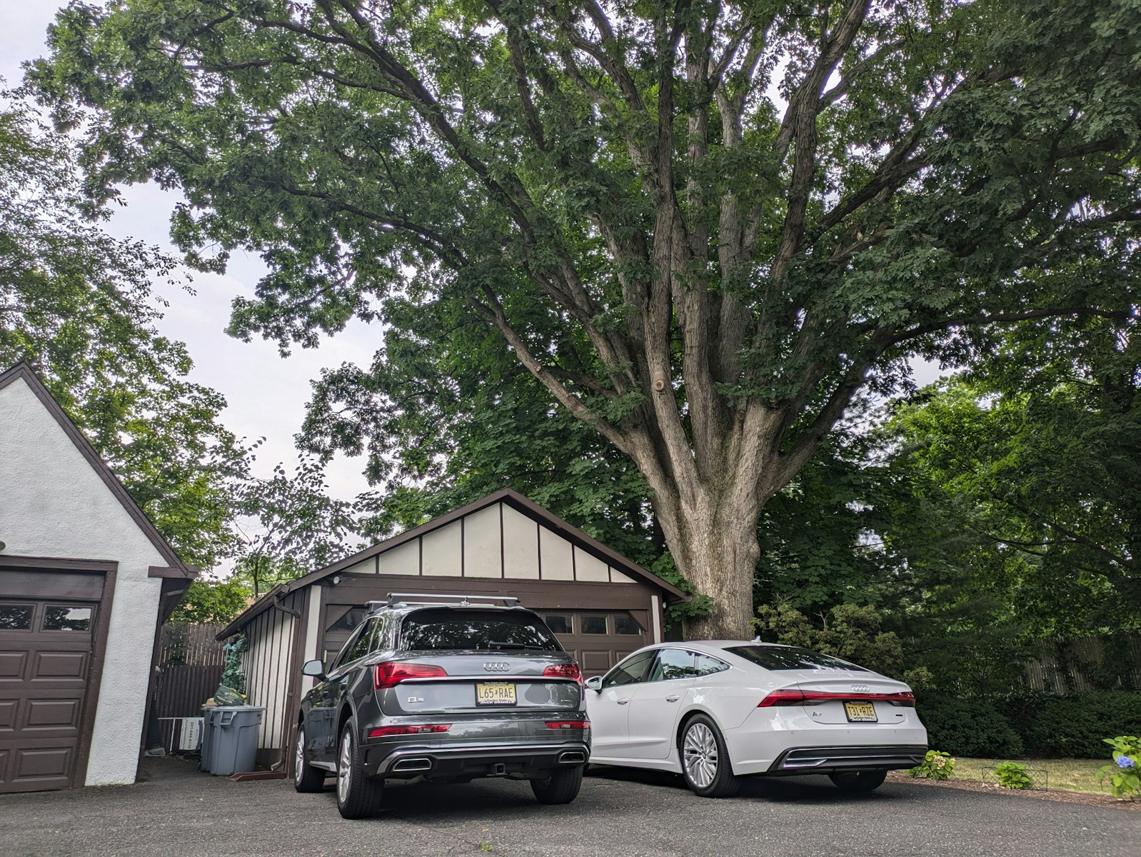 Two cars parked in front of a garage.