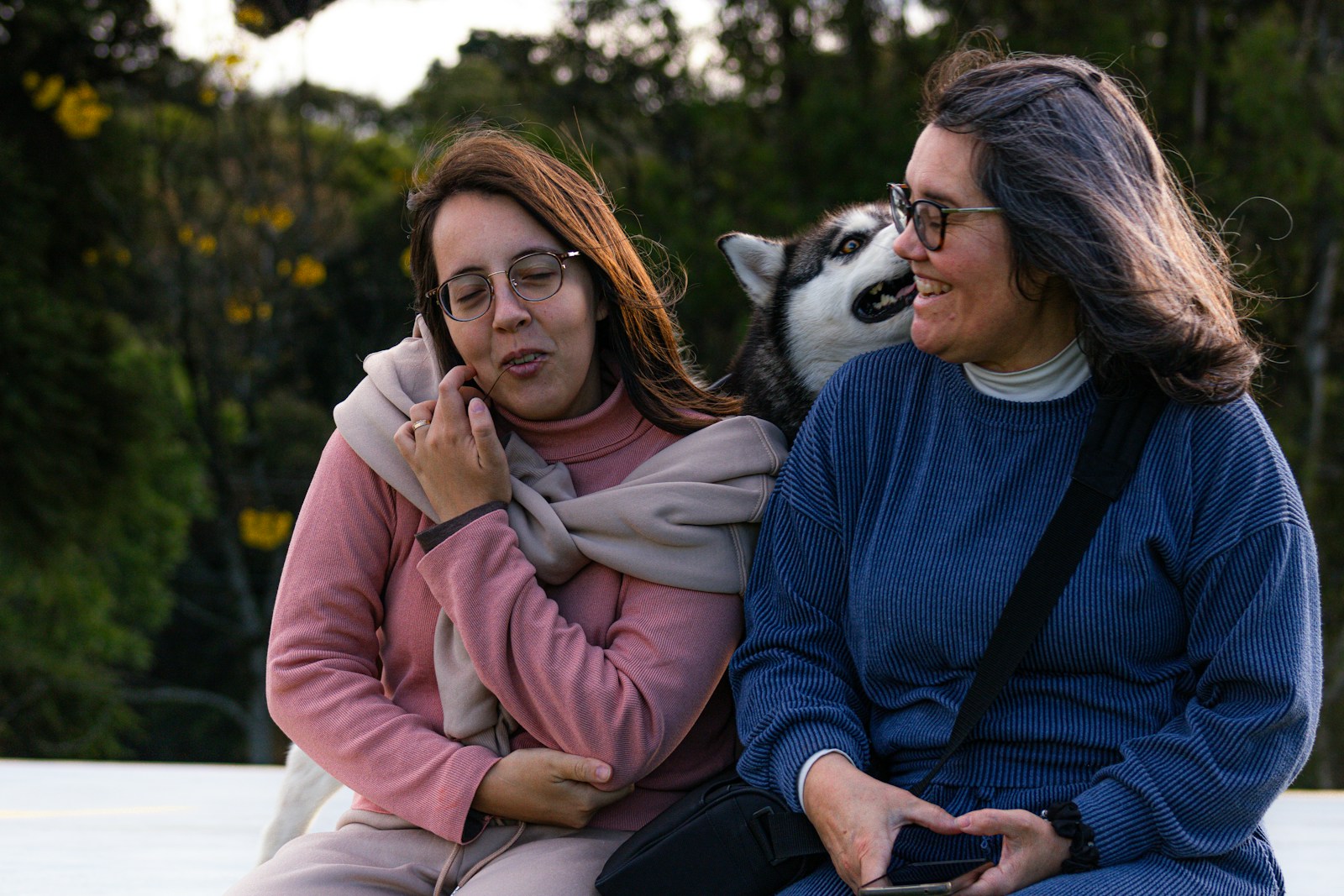 Two women and a husky dog outdoors
