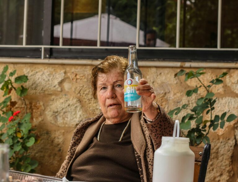 a woman sitting at a table with a bottle of water