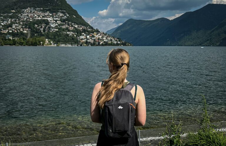 a woman standing by a railing overlooking a body of water