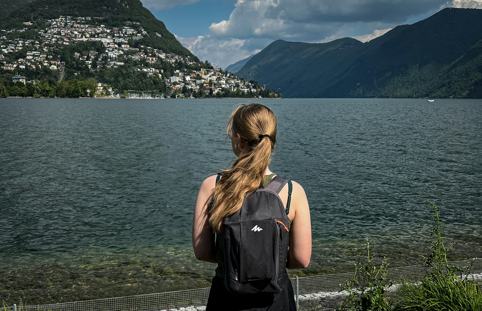 a woman standing by a railing overlooking a body of water
