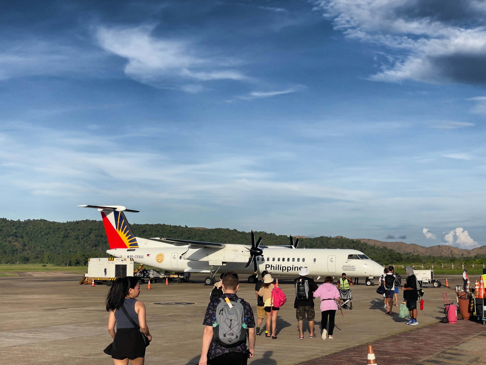 Passengers boarding a small airplane on the tarmac.