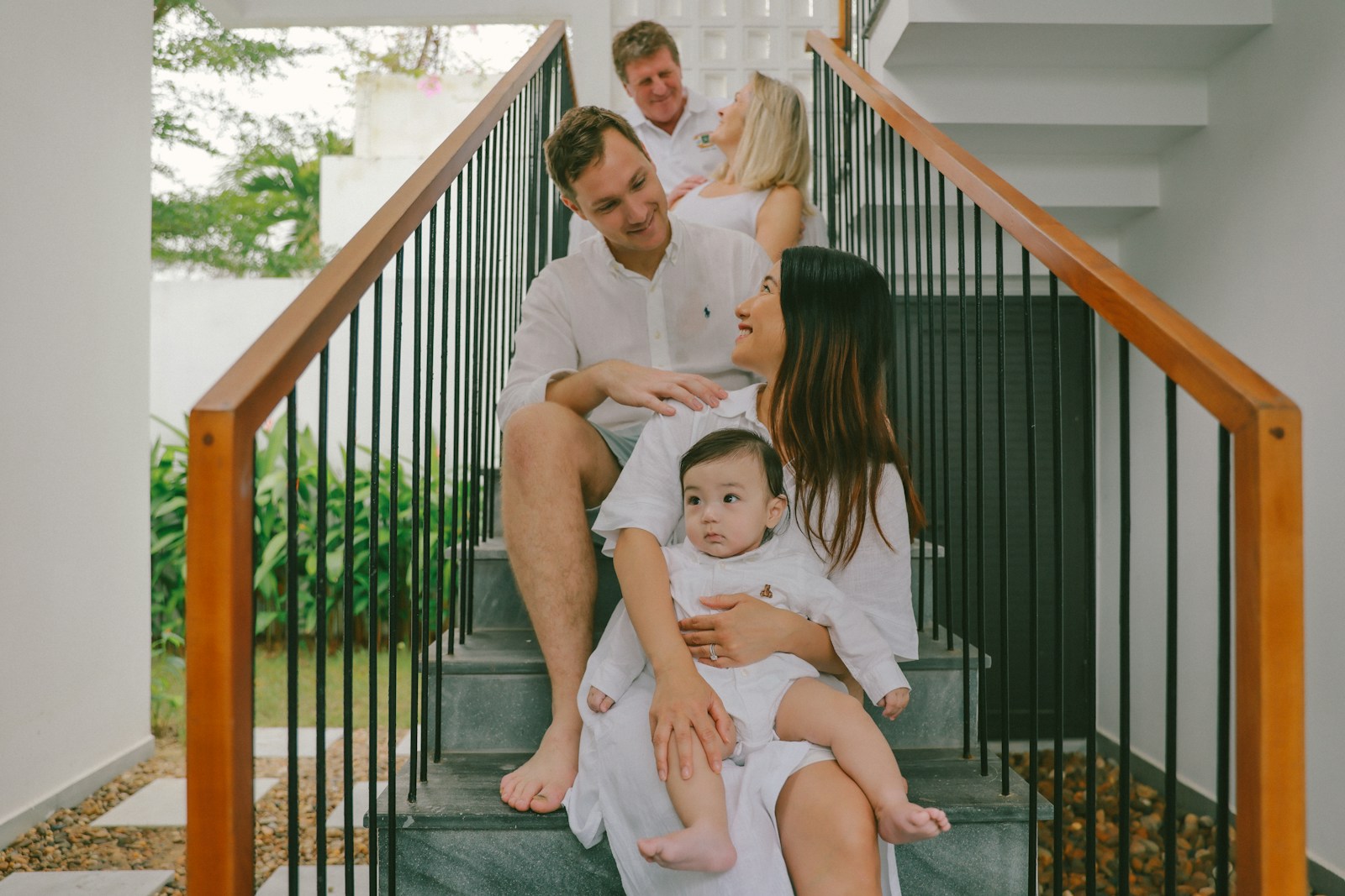 Family posing on stairs in white outfits