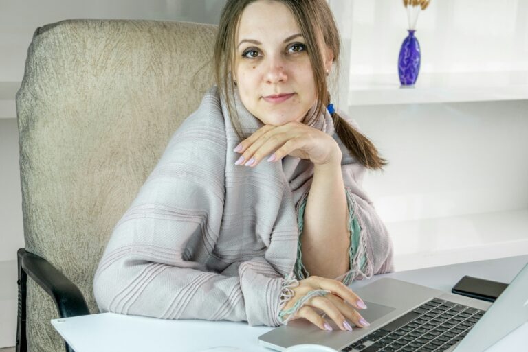 a woman sitting in front of a laptop computer