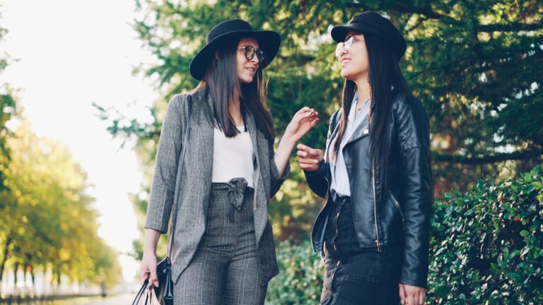 Two women wearing hats talking outdoors