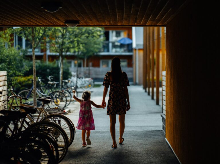 a woman and a little girl walking down a walkway