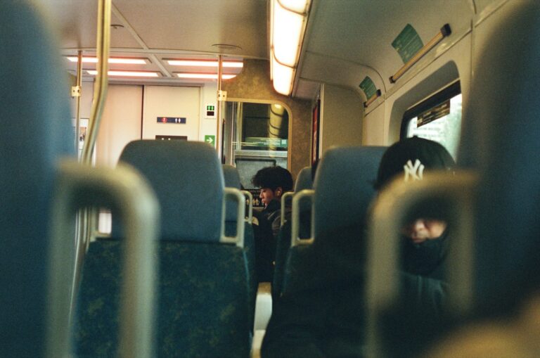People sit on a train, traveling.