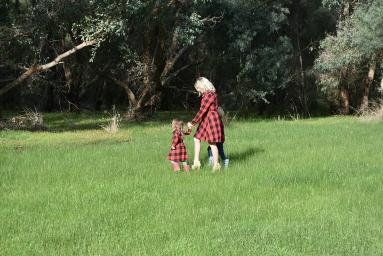 a woman and a child are playing in a field