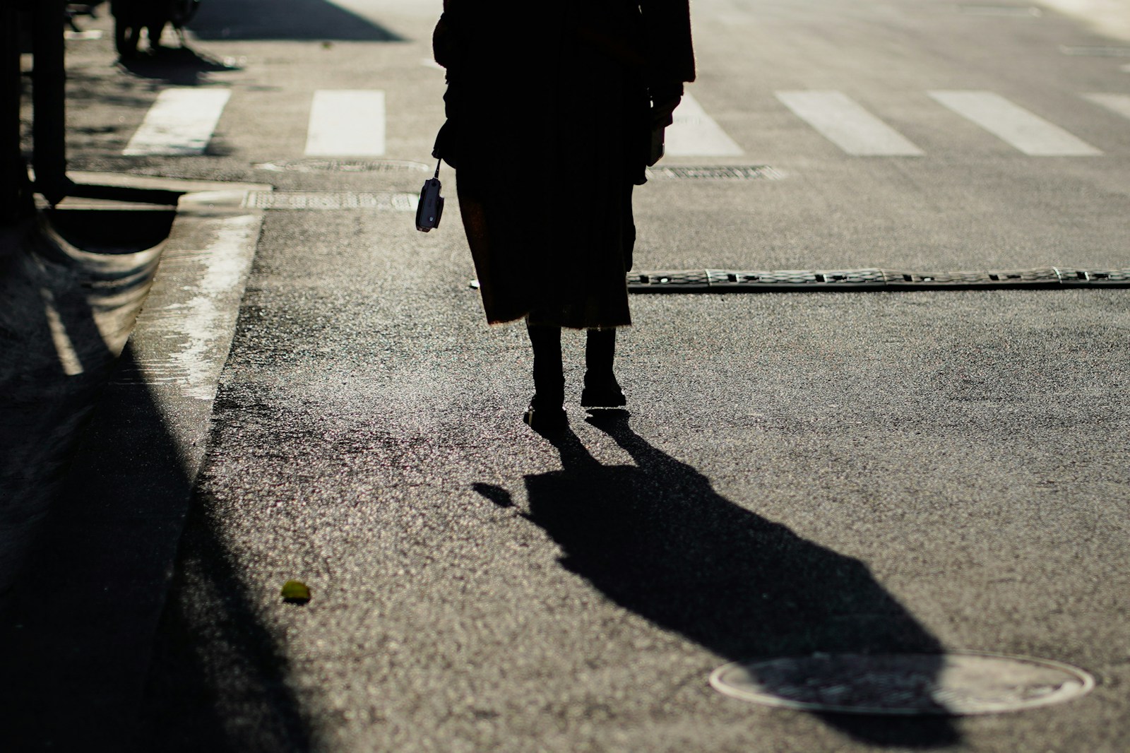 woman in black coat walking on the street during daytime