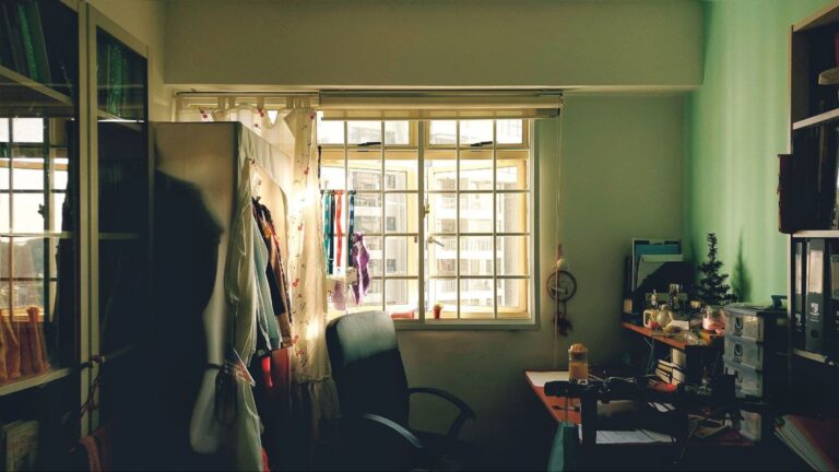 a room with a desk, chair and a window