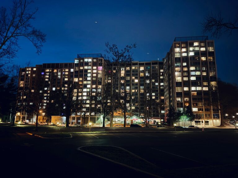 Apartment building illuminated at night with many lit windows.