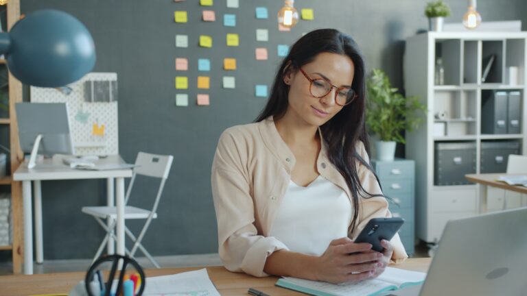 Woman looking at her phone in an office.