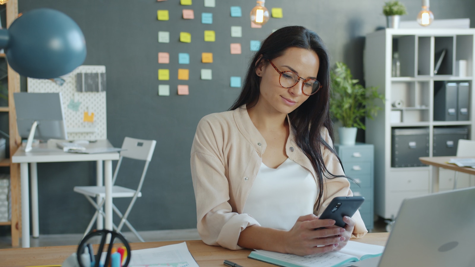 Woman looking at her phone in an office.