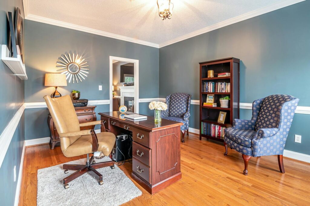 Contemporary home office with elegant furniture and blue walls, creating a cozy workspace.