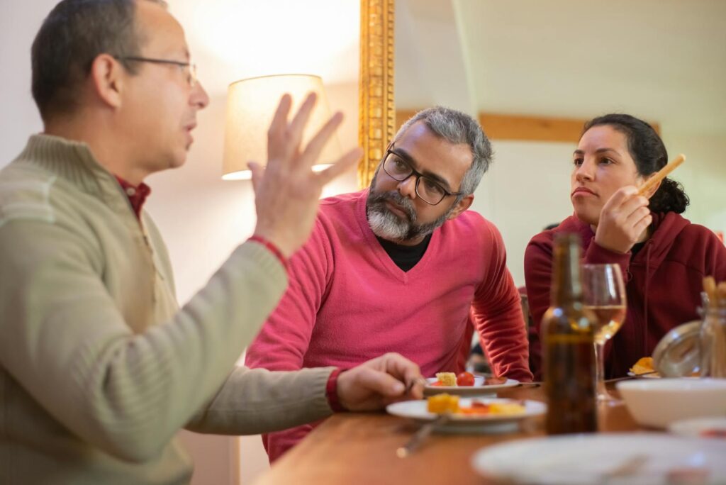 A family enjoying a casual meal and engaging conversation in a cozy indoor setting in Portugal.