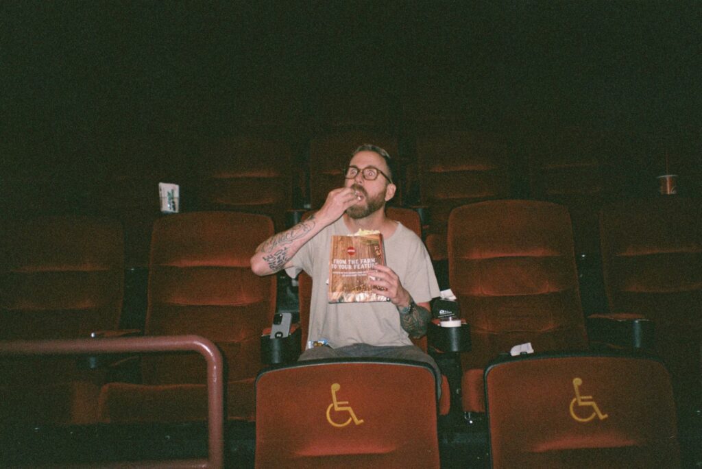Man eating snacks in an empty movie theater
